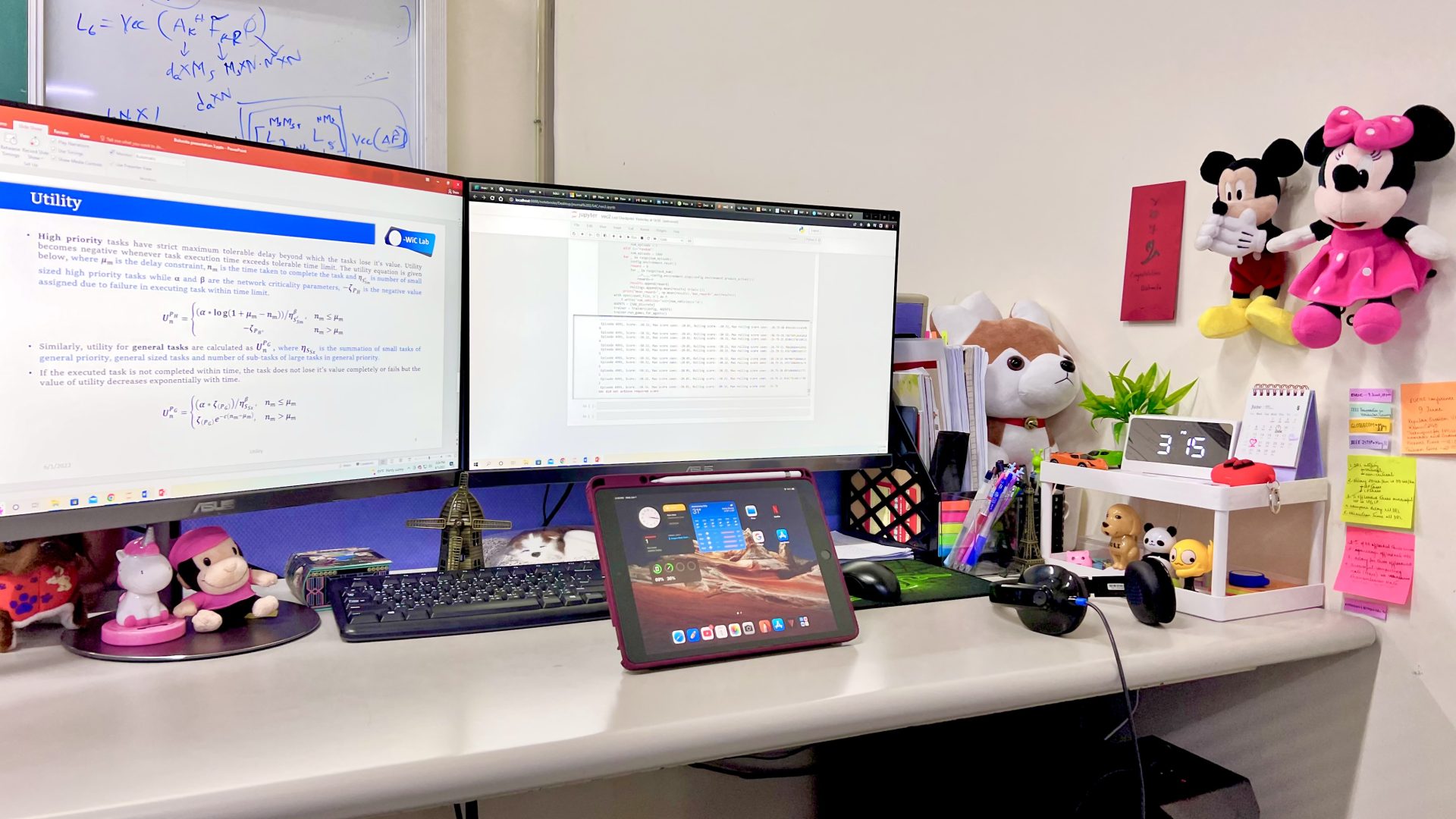 A lab desk with two monitors, a tablet and a keyboard