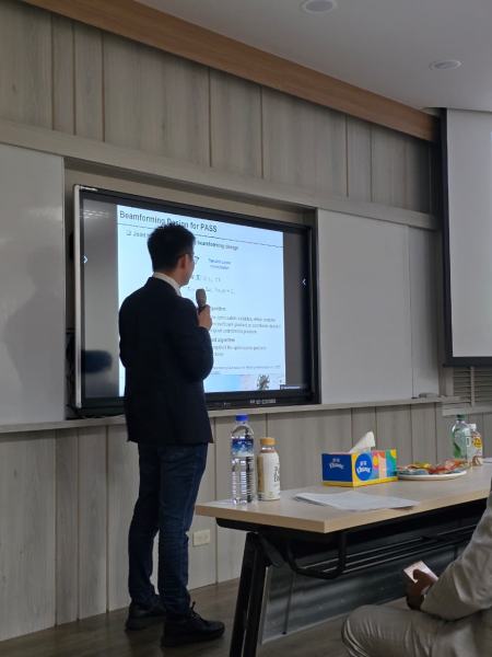 A speaker holding a microphone presents a slide titled “Beamforming Design for PASS” on the seminar-room display.