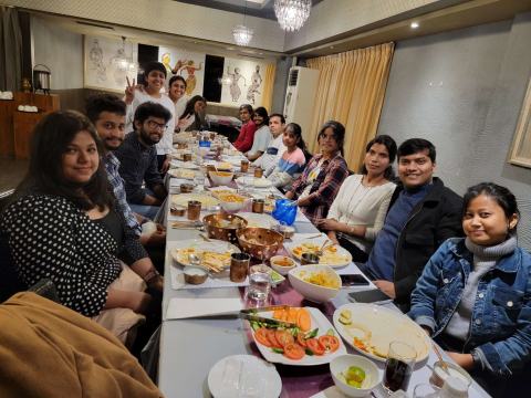 Lab members sharing a meal at a long table.
