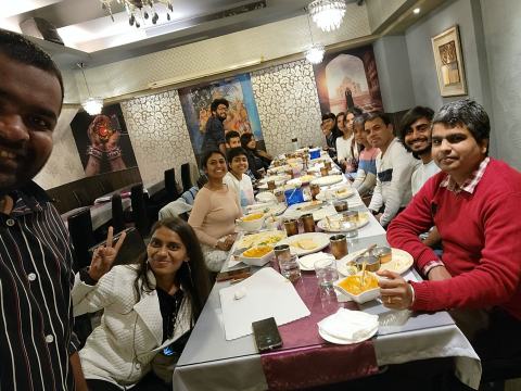Lab members around a dinner table set with dishes.