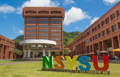 Colourful NSYSU letters on the lawn in front of a campus building.
